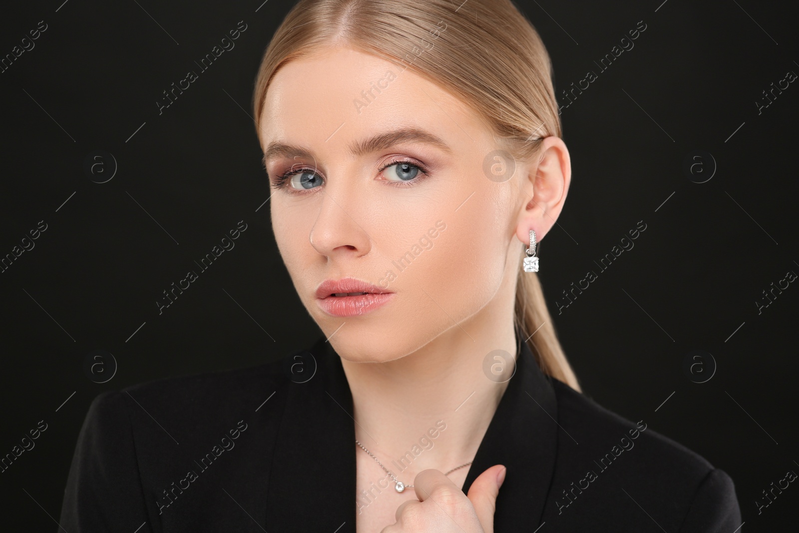 Photo of Beautiful young woman with elegant jewelry on black background