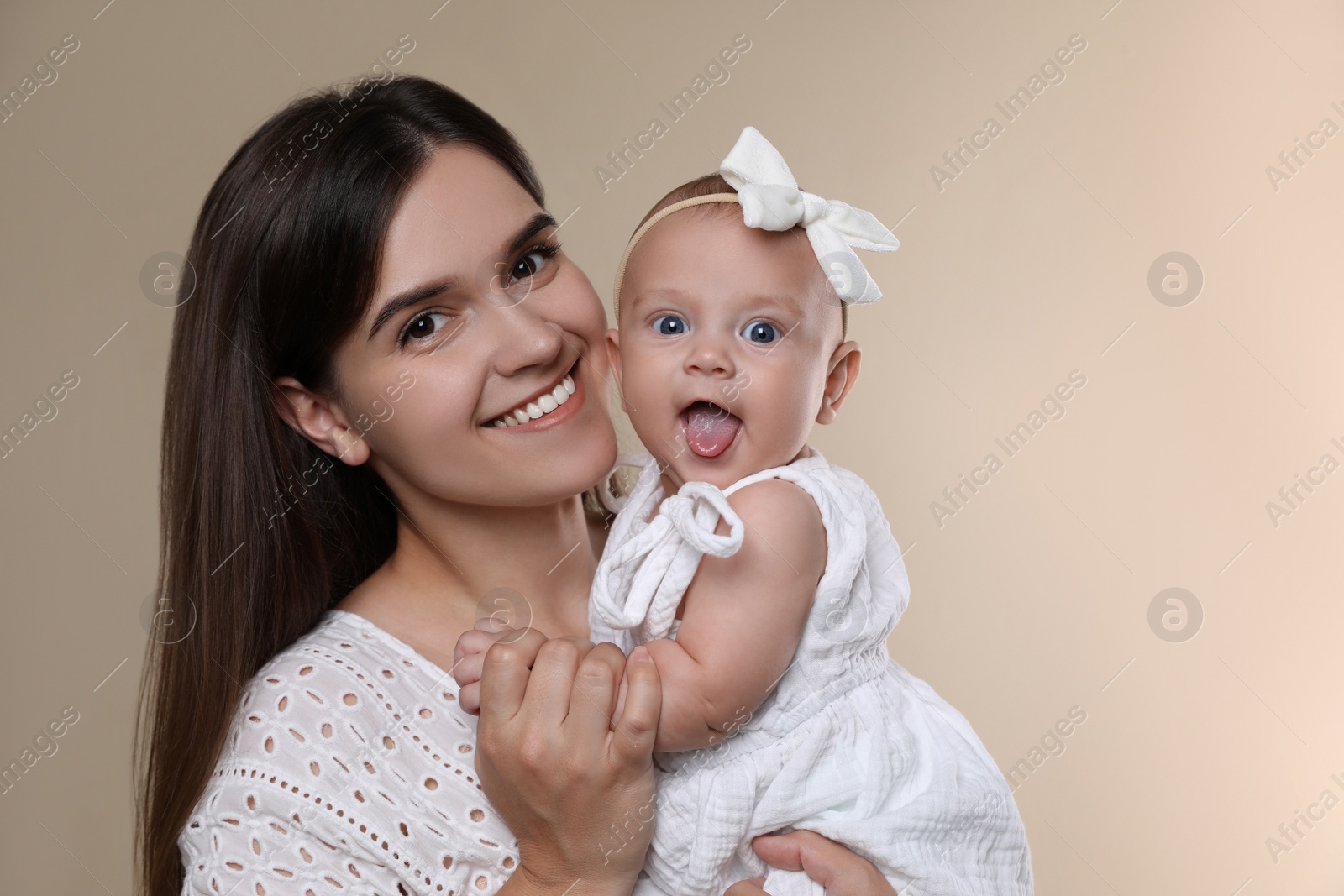 Photo of Beautiful mother with her cute baby on beige background