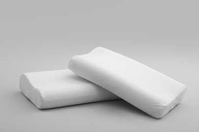 Clean soft orthopedic pillows on grey background