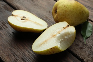 Whole and halves of tasty fresh pears on wooden table, closeup