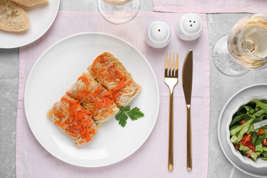 Photo of Delicious cabbage rolls served on grey table, flat lay