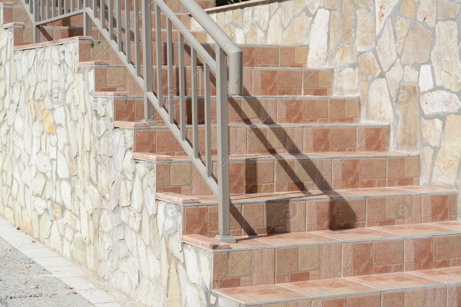 Photo of Beautiful tiled stairs with metal railings outdoors