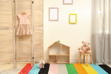 Modern folding screen in stylish baby room interior