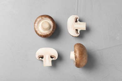 Photo of Flat lay composition of fresh champignon mushrooms on grey background