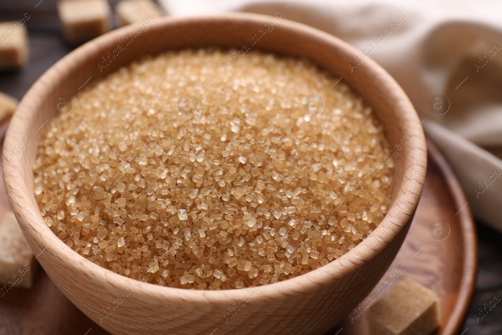 Photo of Brown sugar in bowl on table, closeup