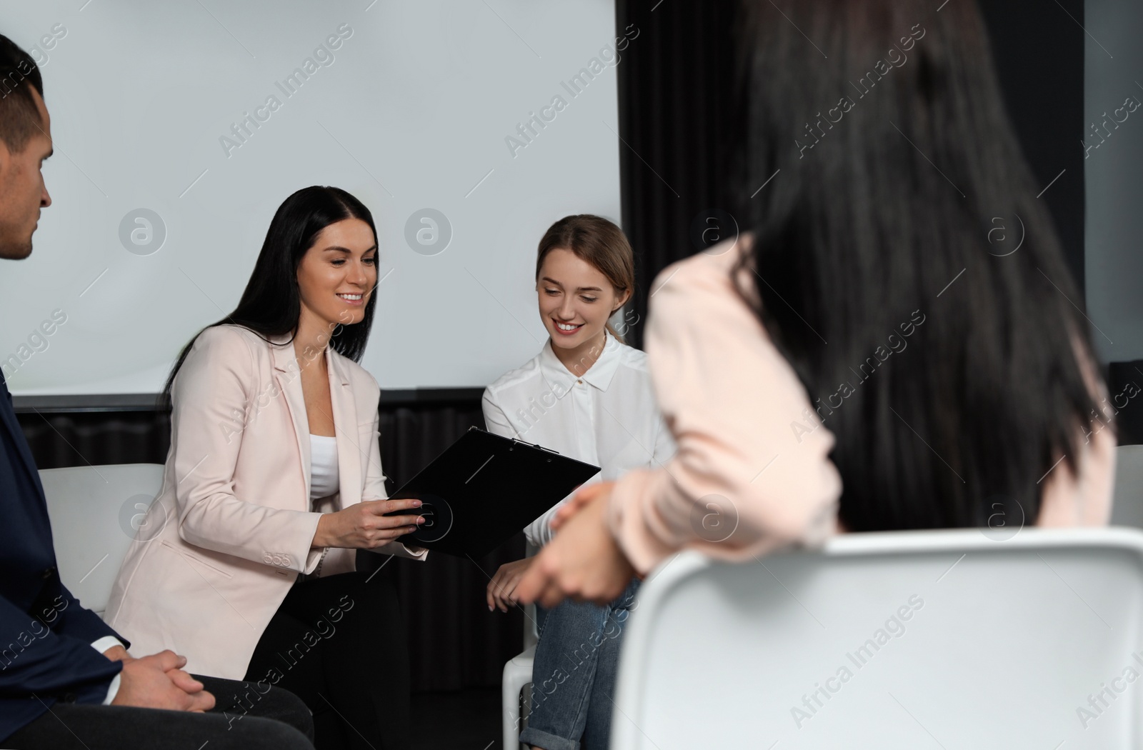 Photo of Business people at seminar in conference room with video projection screen