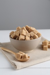 Photo of Brown sugar cubes on white wooden table