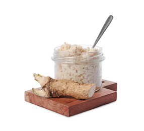 Photo of Wooden board with glass jar of tasty prepared horseradish, spoon and root isolated on white