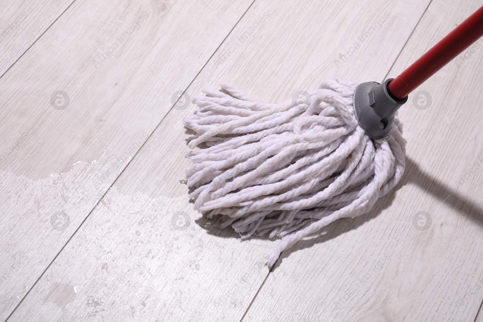 Photo of Cleaning dirty wooden floor with mop indoors