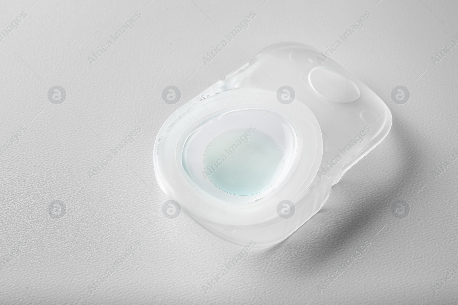 Photo of Container with contact lens on white table