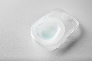 Container with contact lens on white table
