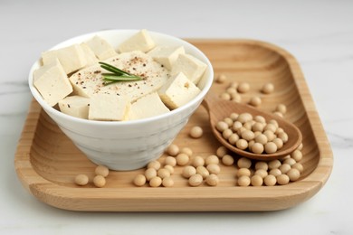 Pieces of delicious tofu with rosemary and soy on white wooden table