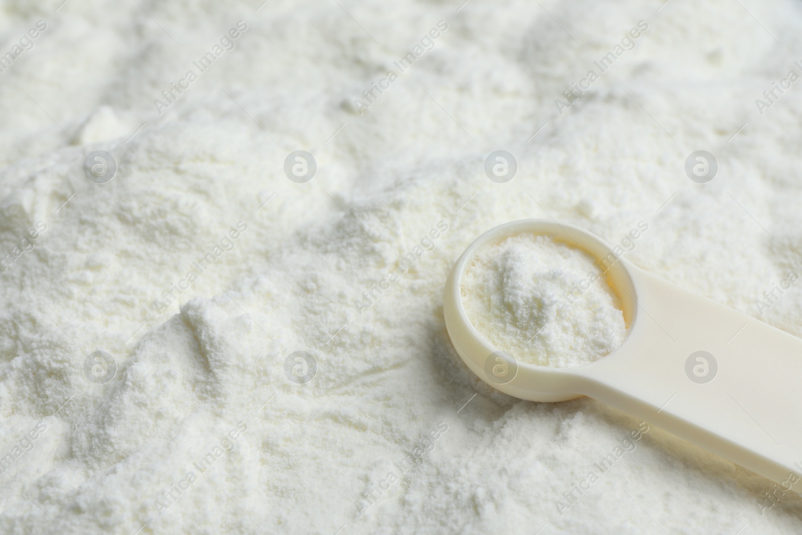 Photo of Powdered infant formula and scoop, closeup with space for text. Baby milk