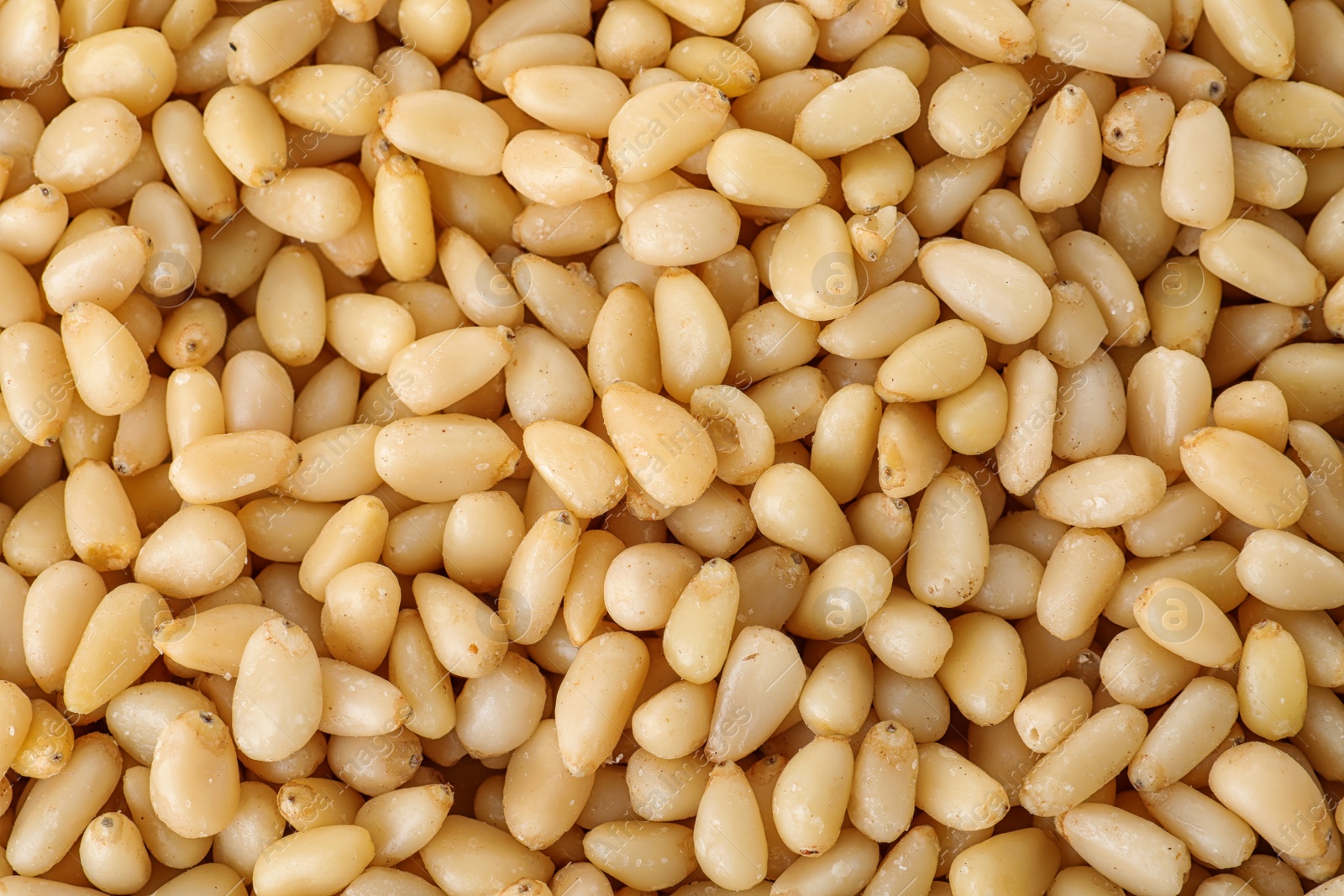 Photo of Pile of pine nuts as background, top view
