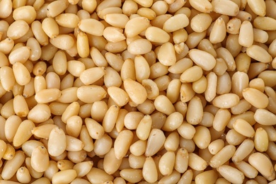 Pile of pine nuts as background, top view