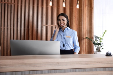 Portrait of receptionist with headset at desk in lobby