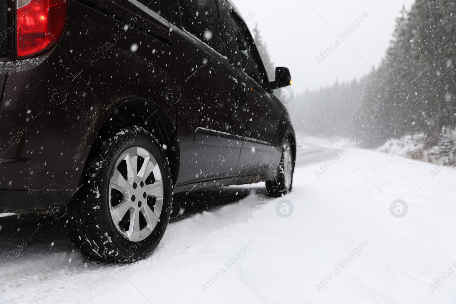 Photo of Country road with car on snowy winter day