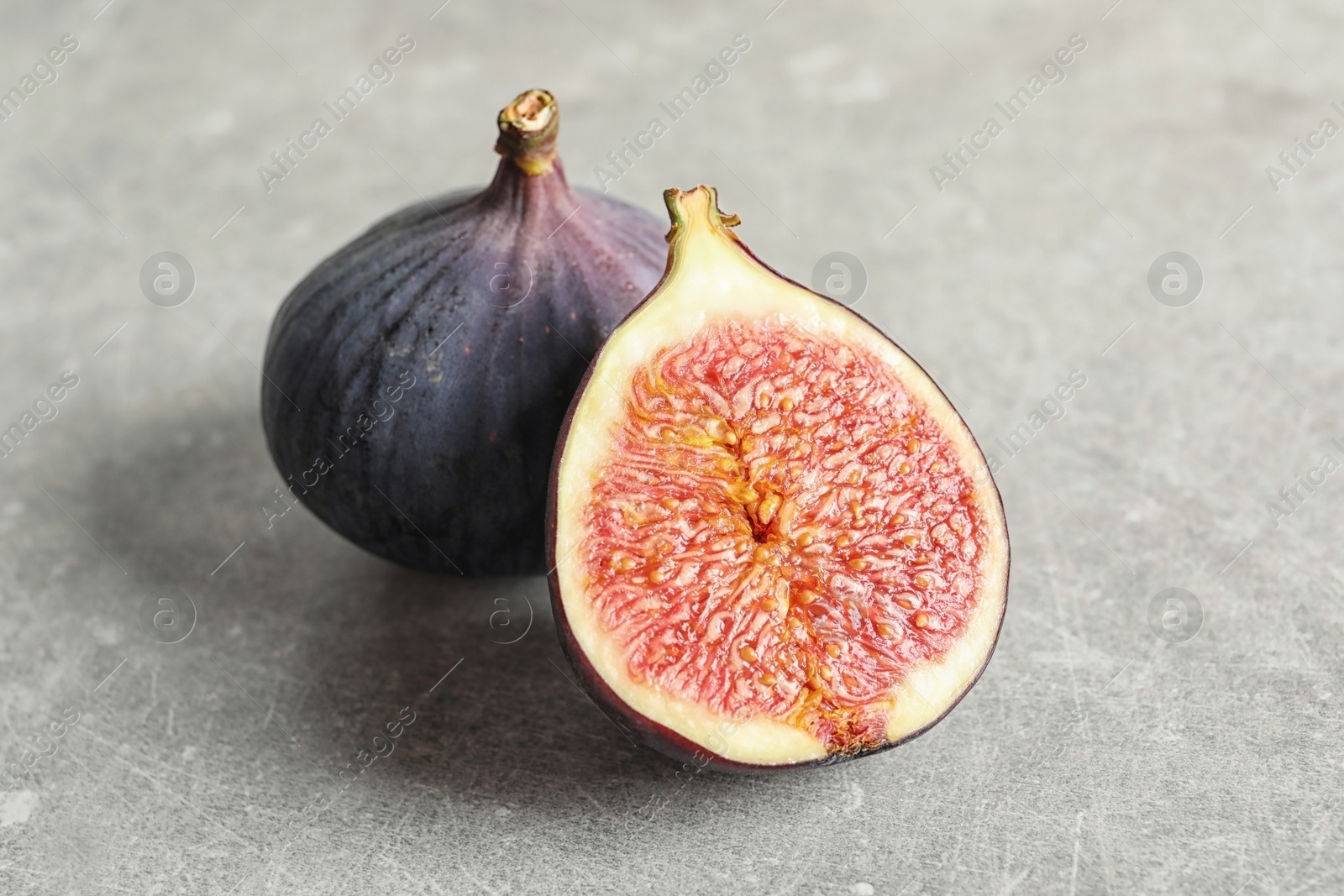 Photo of Fresh ripe figs on gray background. Tropical fruit