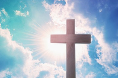 Image of Silhouette of cross against blue sky on sunny day. Christian religion