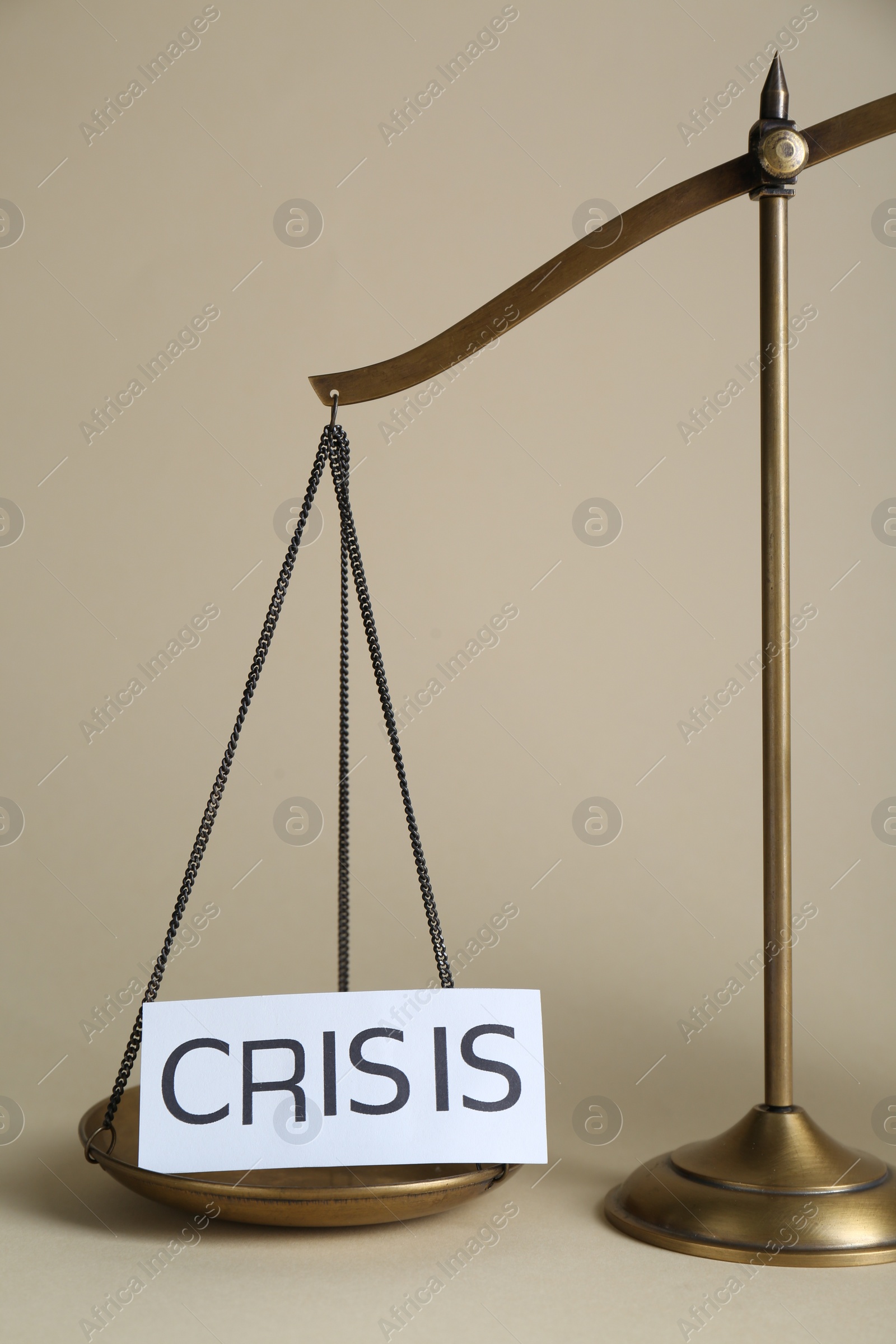 Photo of Scale with word Crisis on beige background