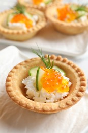 Delicious canapes with red caviar on table, closeup