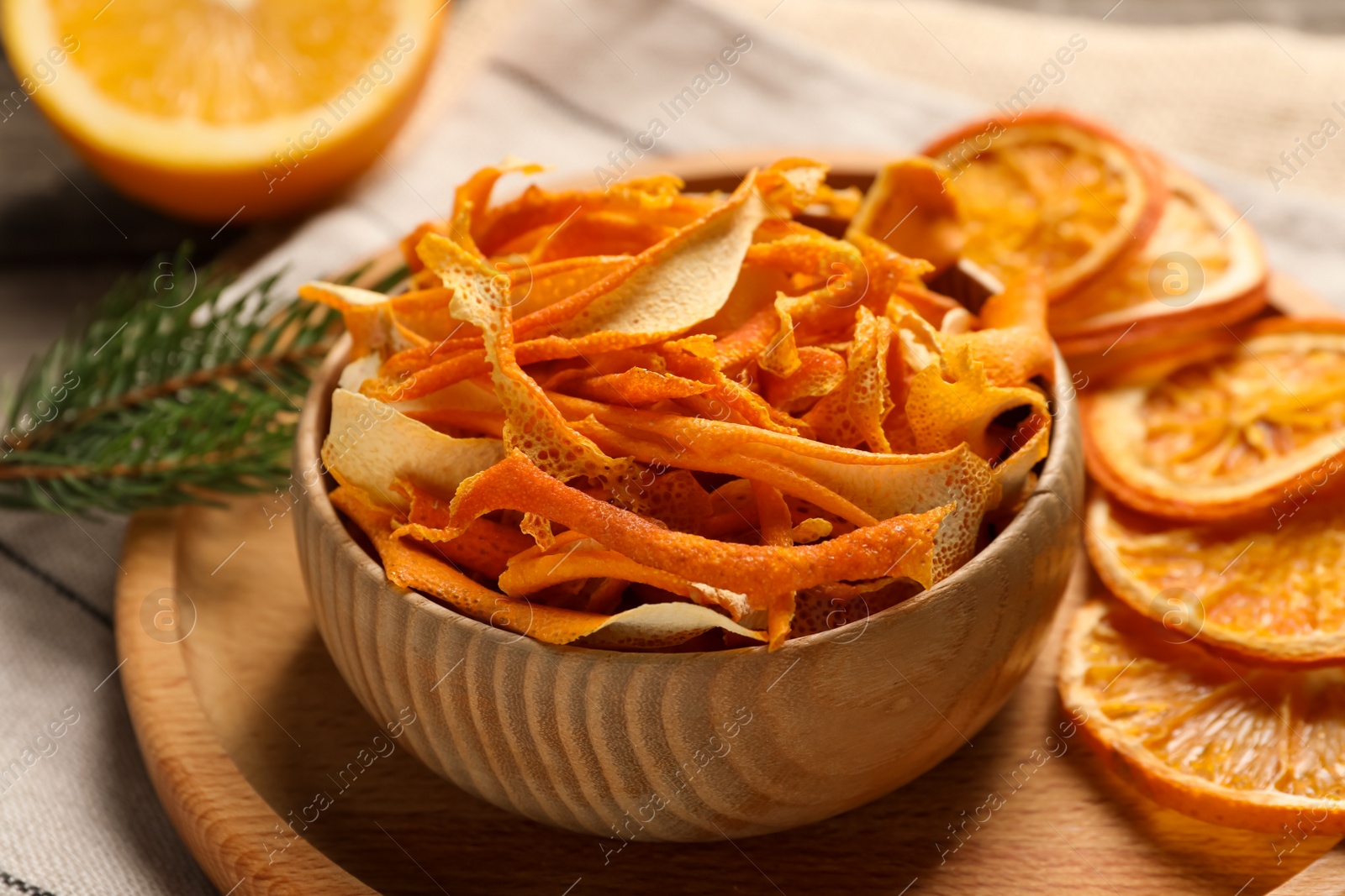 Photo of Dry orange peels and slices on wooden board, closeup
