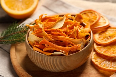 Dry orange peels and slices on wooden board, closeup