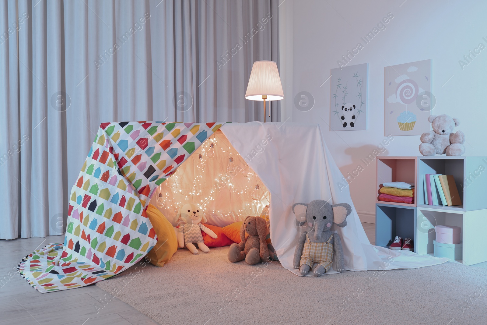 Photo of Play tent decorated with festive lights in modern child's room