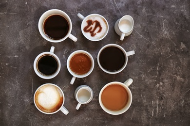 Photo of Cups of fresh aromatic coffee on grey background, top view