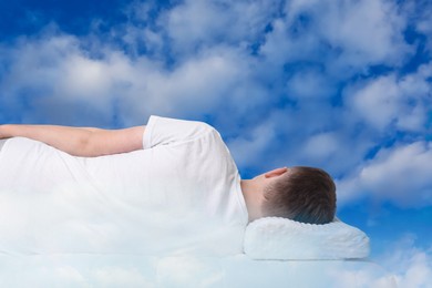 Image of Man sleeping on orthopedic pillow against blue sky