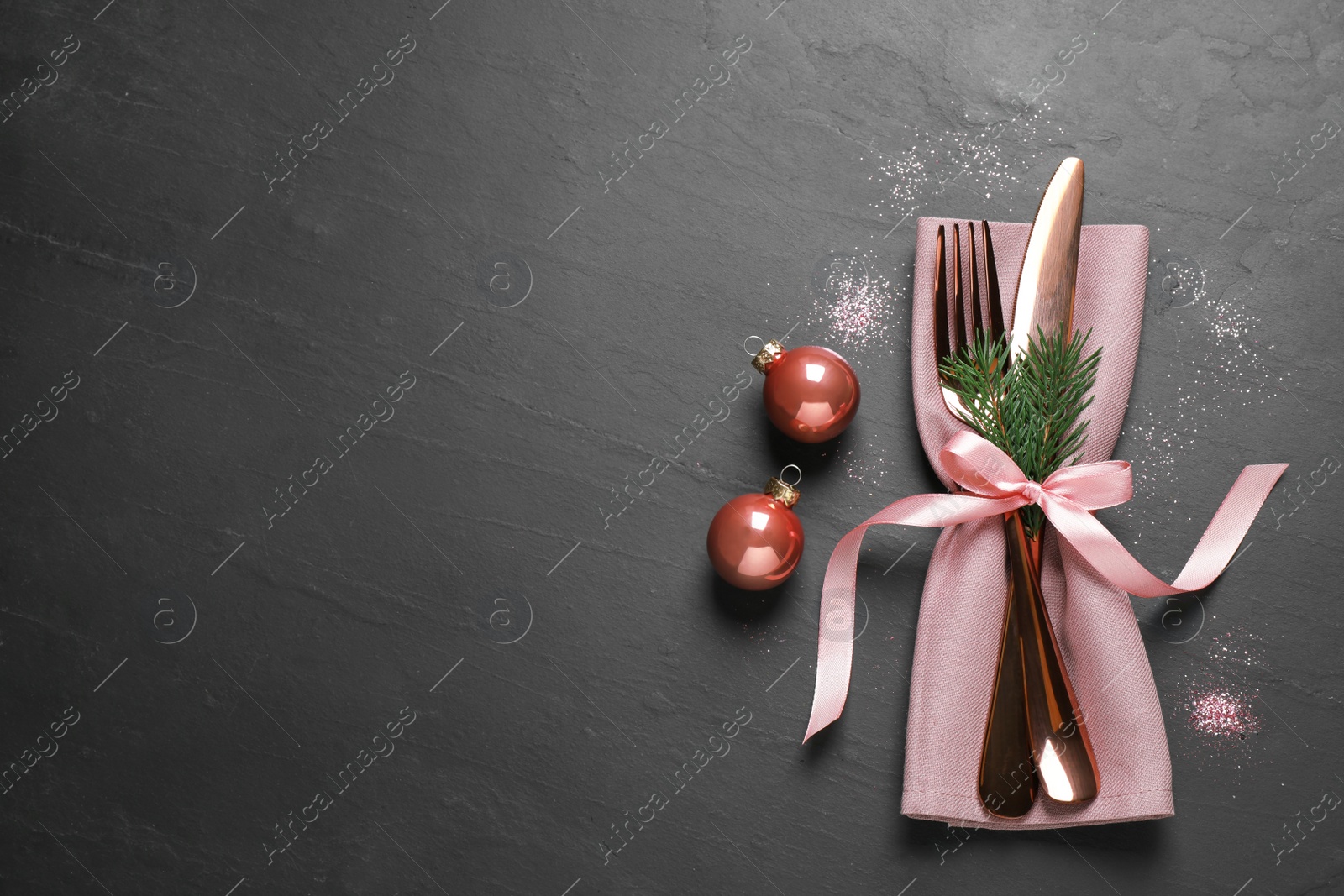 Photo of Cutlery set on black table, top view with space for text. Christmas celebration