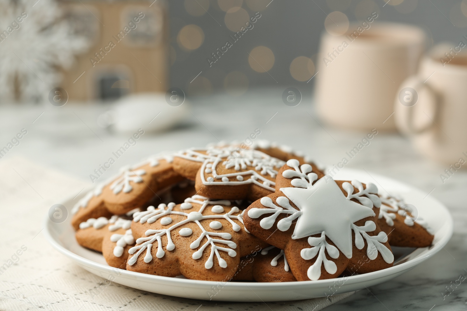Photo of Tasty Christmas cookies with icing on white marble table, closeup