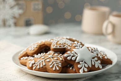 Tasty Christmas cookies with icing on white marble table, closeup