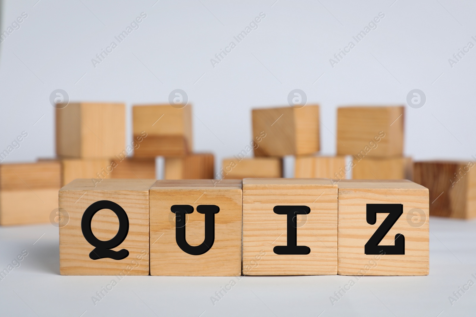 Photo of Wooden cubes with word Quiz on white background. Space for text