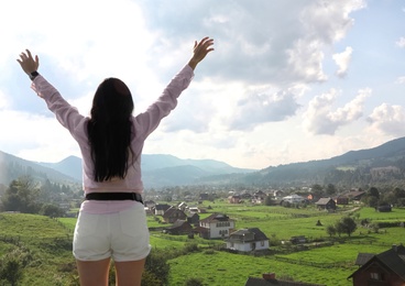 Photo of Young woman enjoying beautiful view of village in mountains