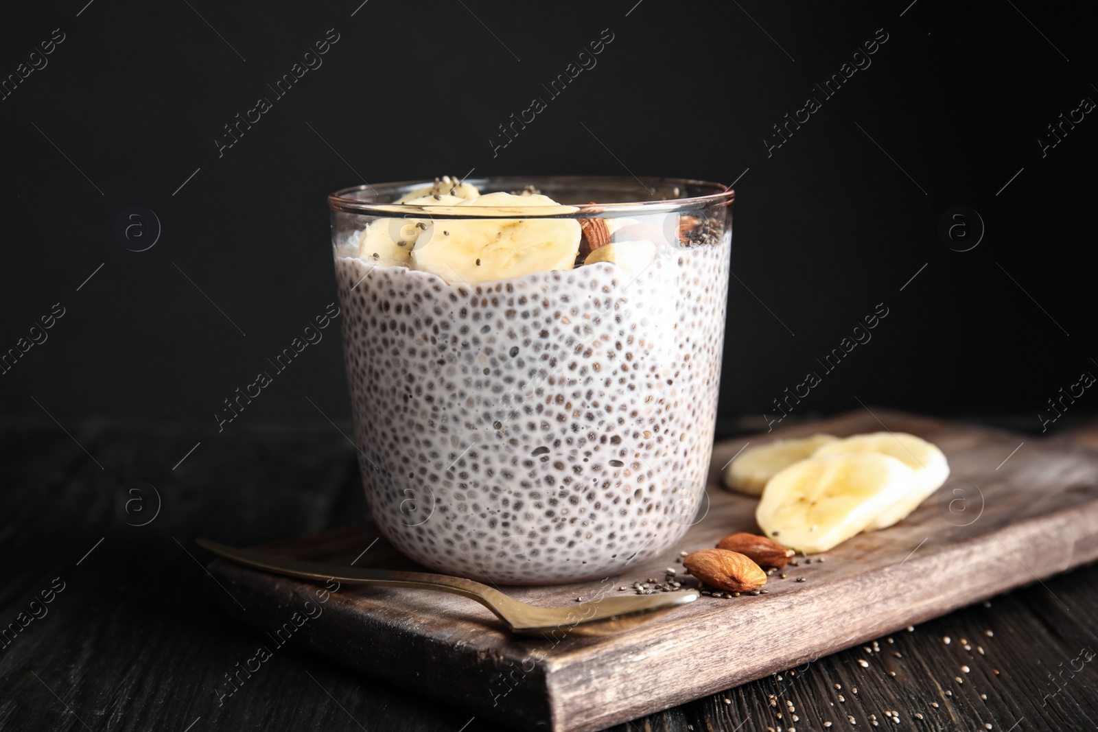 Photo of Dessert bowl of tasty chia seed pudding with banana and nuts served on table