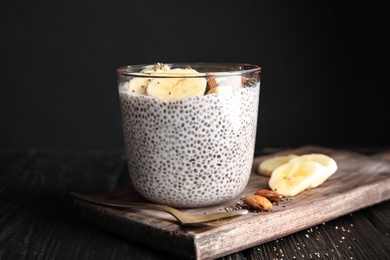 Photo of Dessert bowl of tasty chia seed pudding with banana and nuts served on table