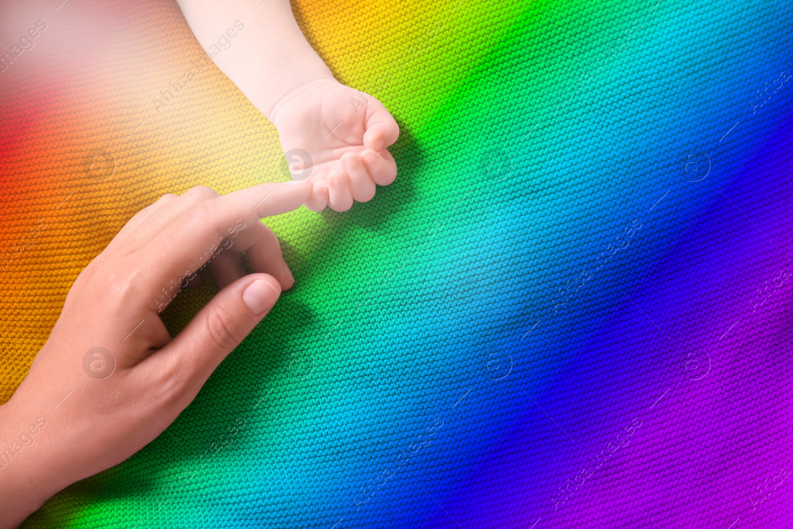 Image of National rainbow baby day. Mother and her little child baby on colorful blanket, top view. Space for text