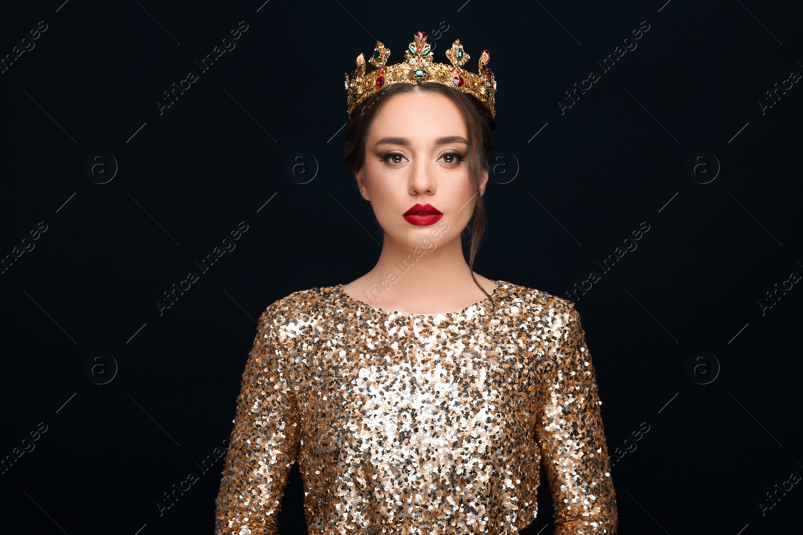 Photo of Beautiful young woman wearing luxurious crown on black background