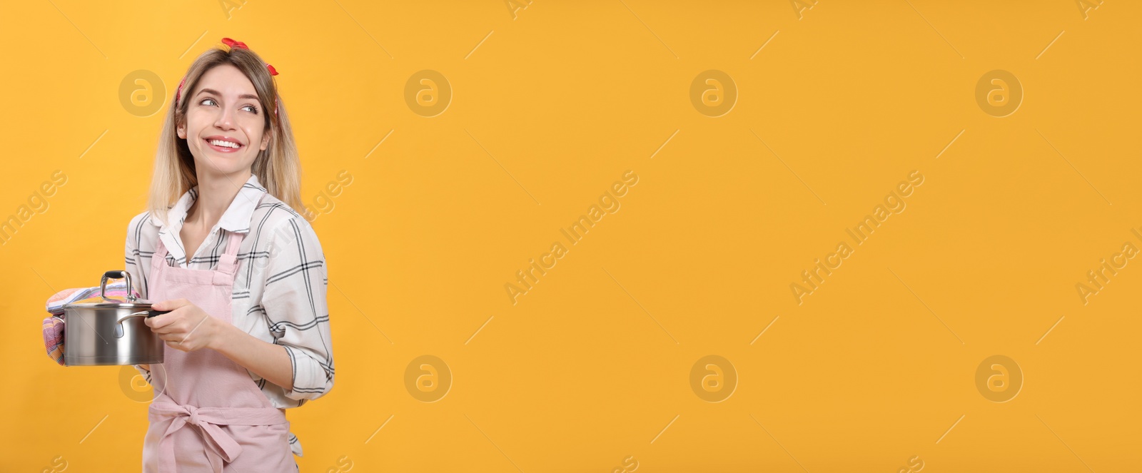 Photo of Young housewife with pot on yellow background. Space for text