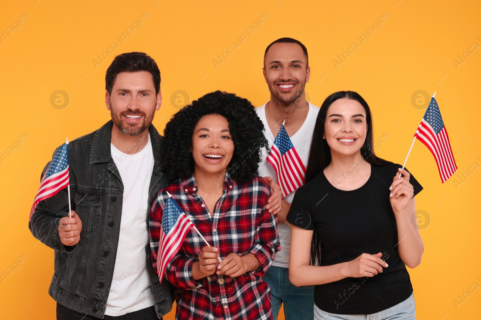 Photo of 4th of July - Independence Day of USA. Happy friends with American flags on yellow background