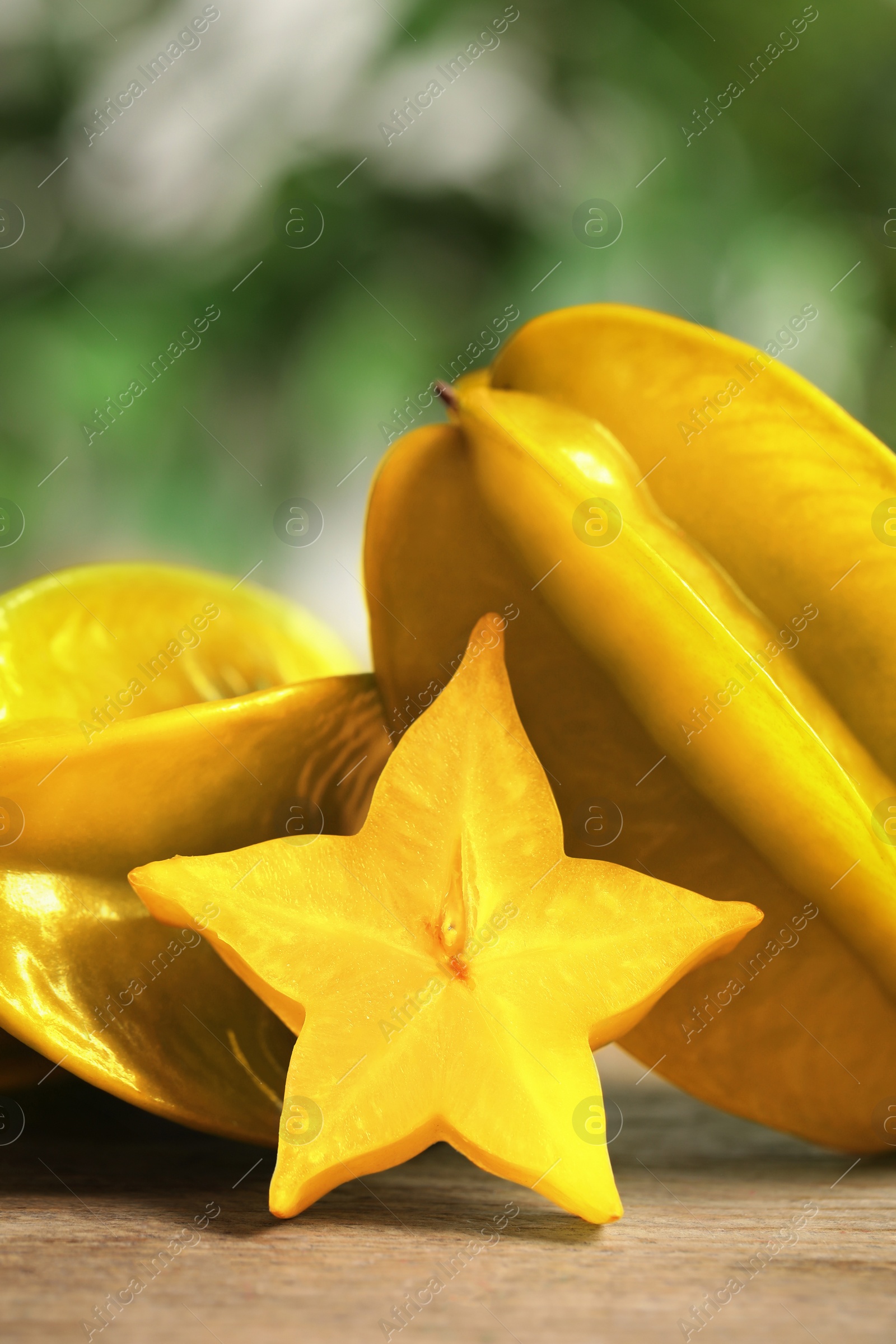 Photo of Delicious carambola fruits and slice on wooden table