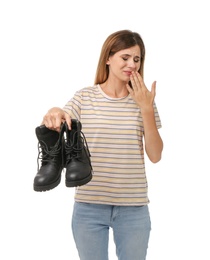 Photo of Woman feeling bad smell from shoes on white background. Air freshener