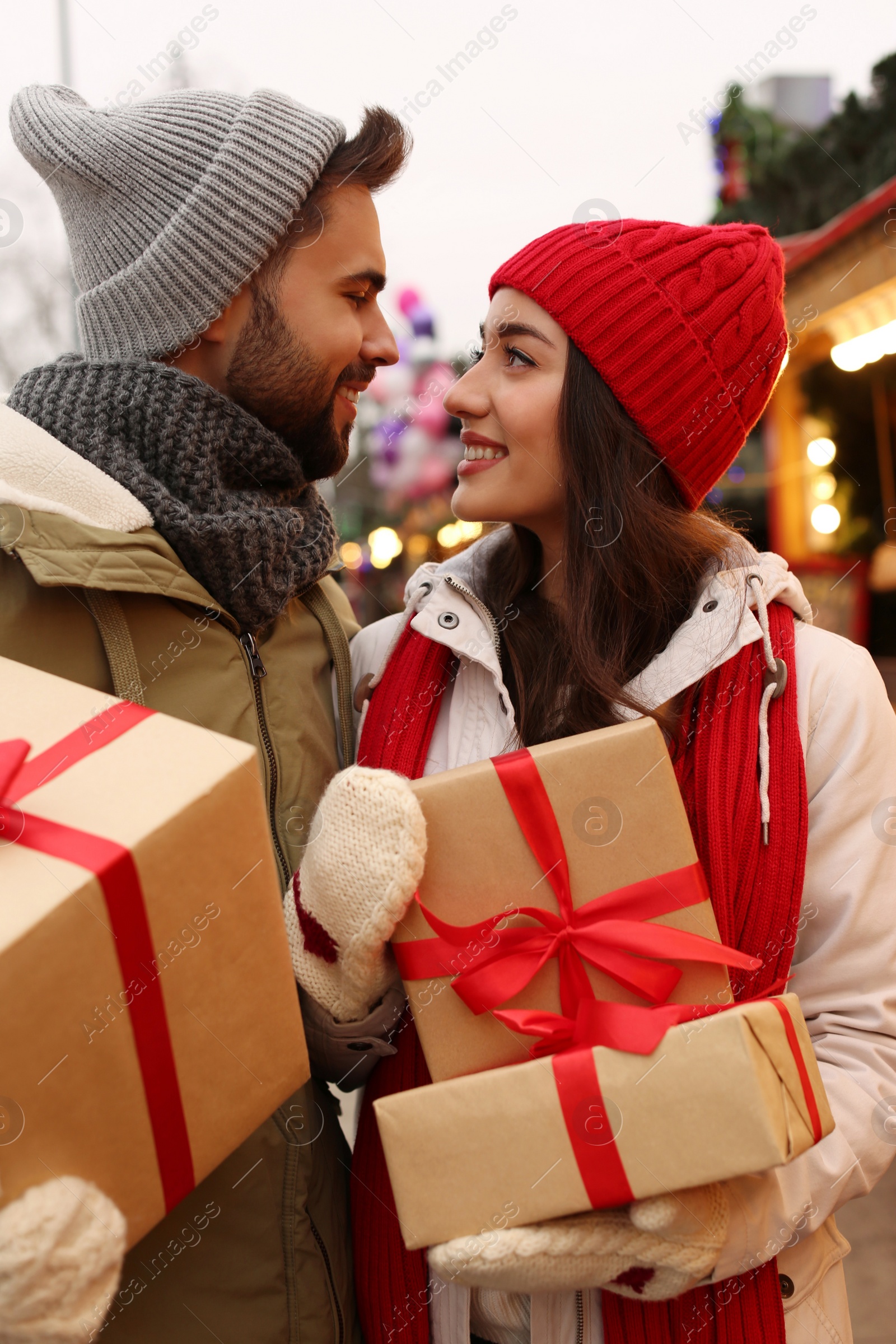 Photo of Lovely couple with Christmas presents at winter fair