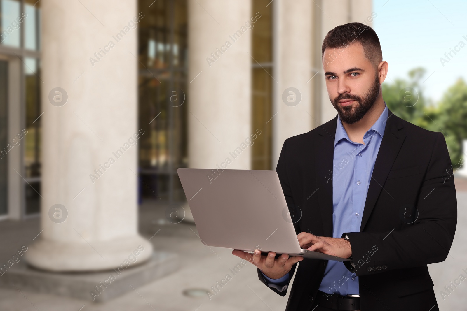 Image of Lawyer with laptop near building outdoors, space for text