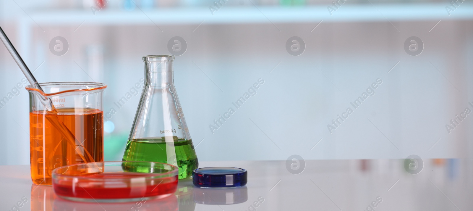 Photo of Laboratory analysis. Different glassware with liquids on white table against blurred background. Space for text