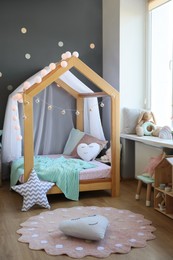 Stylish child room interior with house bed and different toys