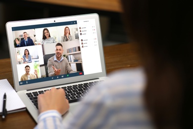 Image of Woman having video chat with team at table, closeup