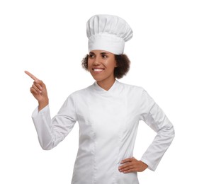 Photo of Happy female chef in uniform pointing at something on white background