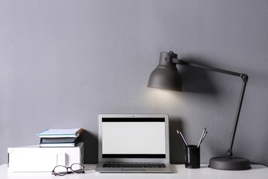 Photo of Modern laptop and stationery on table in office. Space for text